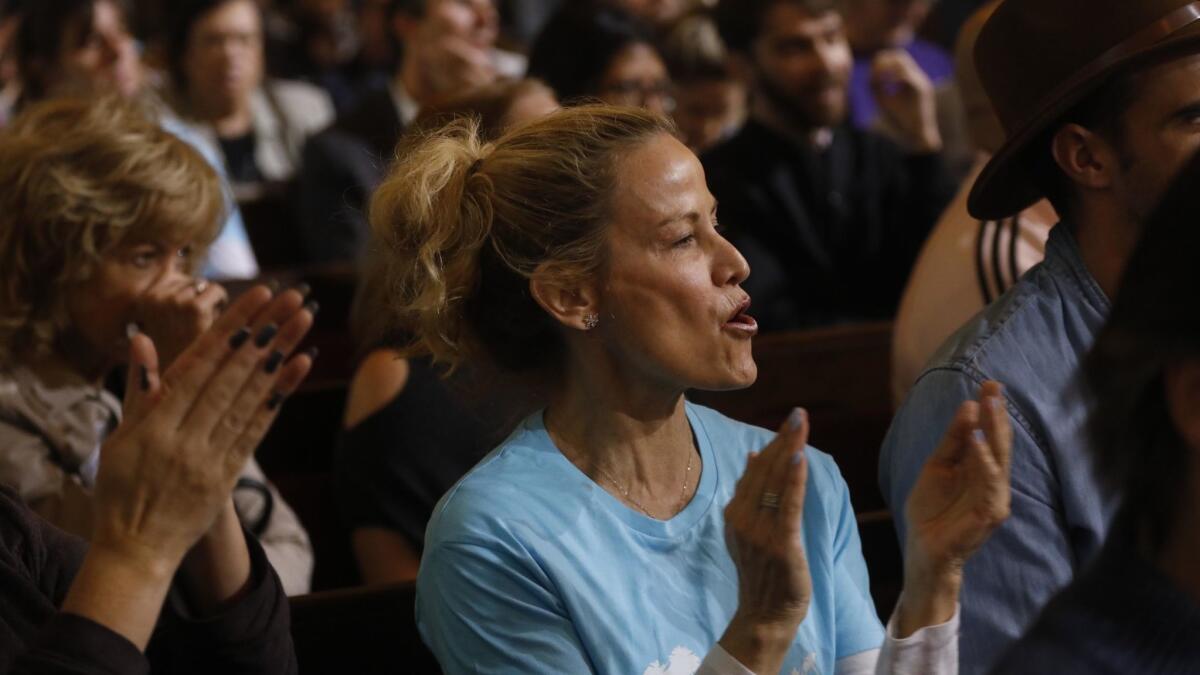 Airbnb supporter Tami Smith, center, applauds a speaker who supports homesharing rentals as the Los Angeles City Council considers the new ordinance.