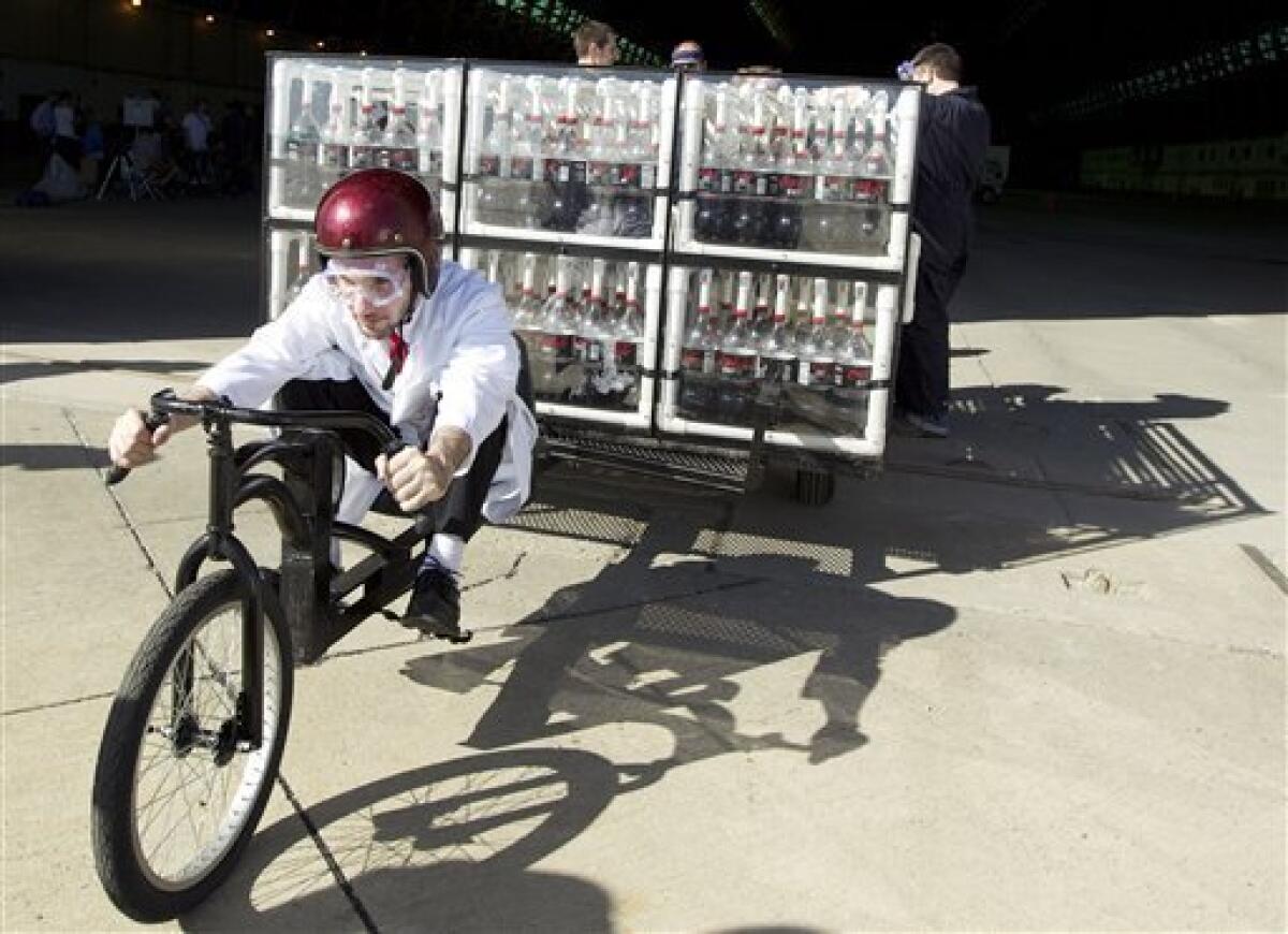 This May 5, 2010 photo released by EepyBird shows Fritz Grobe piloting the Coke Zero & Mentos Rocket Car in its launch in Tustin, Calif. The contraption, created by Grobe and Stephen Voltz, of Buckfield, Maine, features a utility trailer on the back, a modified girl's bike on the front, and is powered using the fizzy reaction created by dropping Mentos into bottles of Coke Zero. (AP Photo/EepyBird) NO SALES