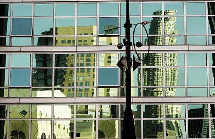 L.A.'s U.S. Bank Tower building is reflected in the mirrored windows of a residential building in South Park. 