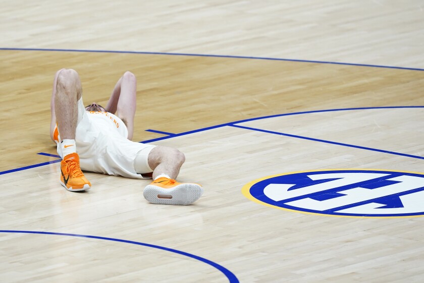 Tennessee's John Fulkerson lies on the court after being fouled by Florida's Omar Payne in the second half of an NCAA college basketball game in the Southeastern Conference Tournament Friday, March 12, 2021, in Nashville, Tenn. Payne was ejected from the game. (AP Photo/Mark Humphrey)