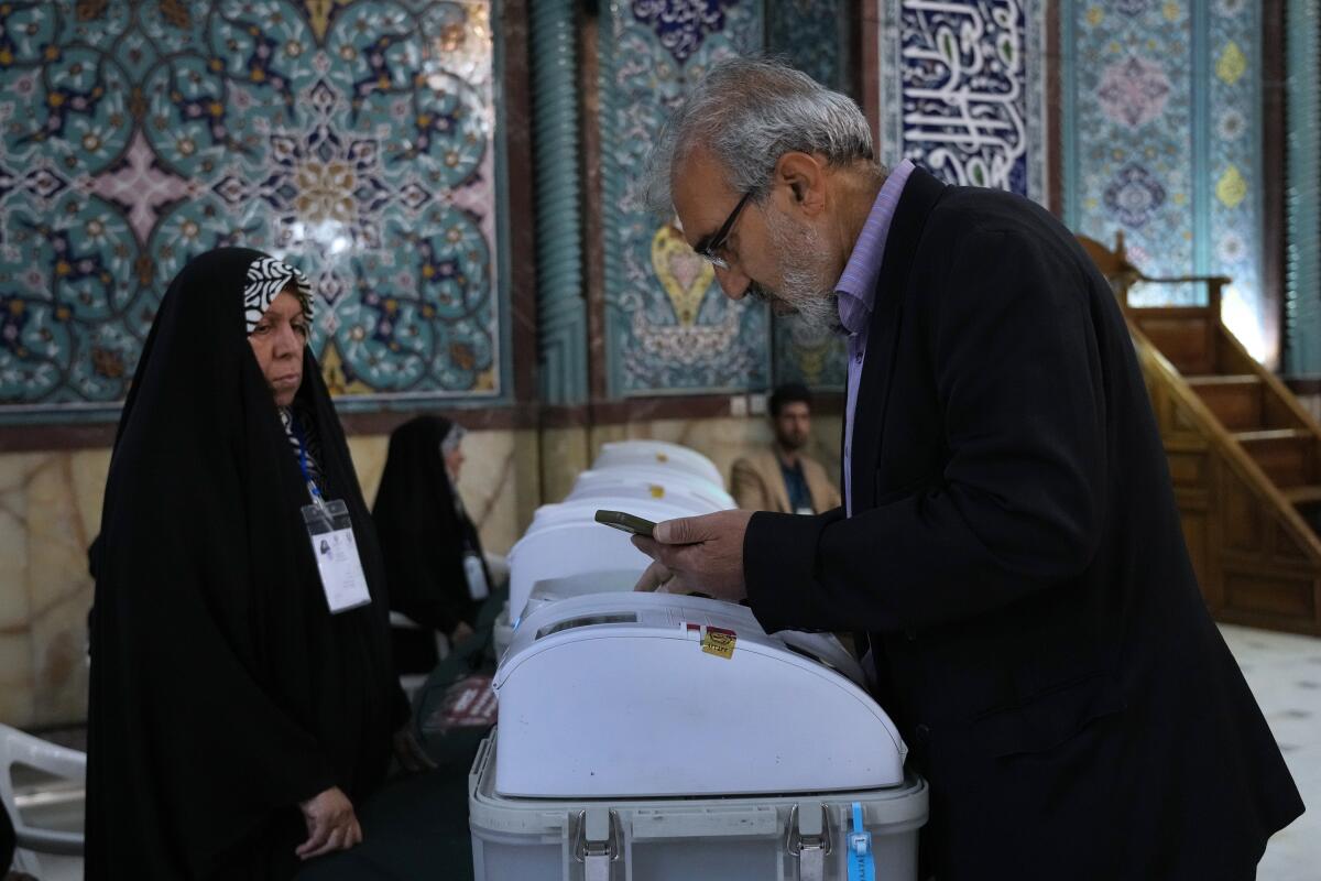 An Iranian man votes during the parliamentary runoff elections at a polling station in Tehran on Friday.
