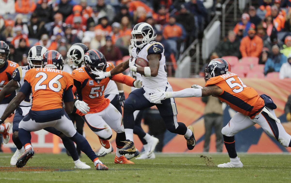 Rams running back Todd Gurley (30) breaks through Denver Broncos linebacker Todd Davis (51) and linebacker Brandon Marshall (54) in there first half at Broncos Stadium at Mile High on Sunday in Denver.