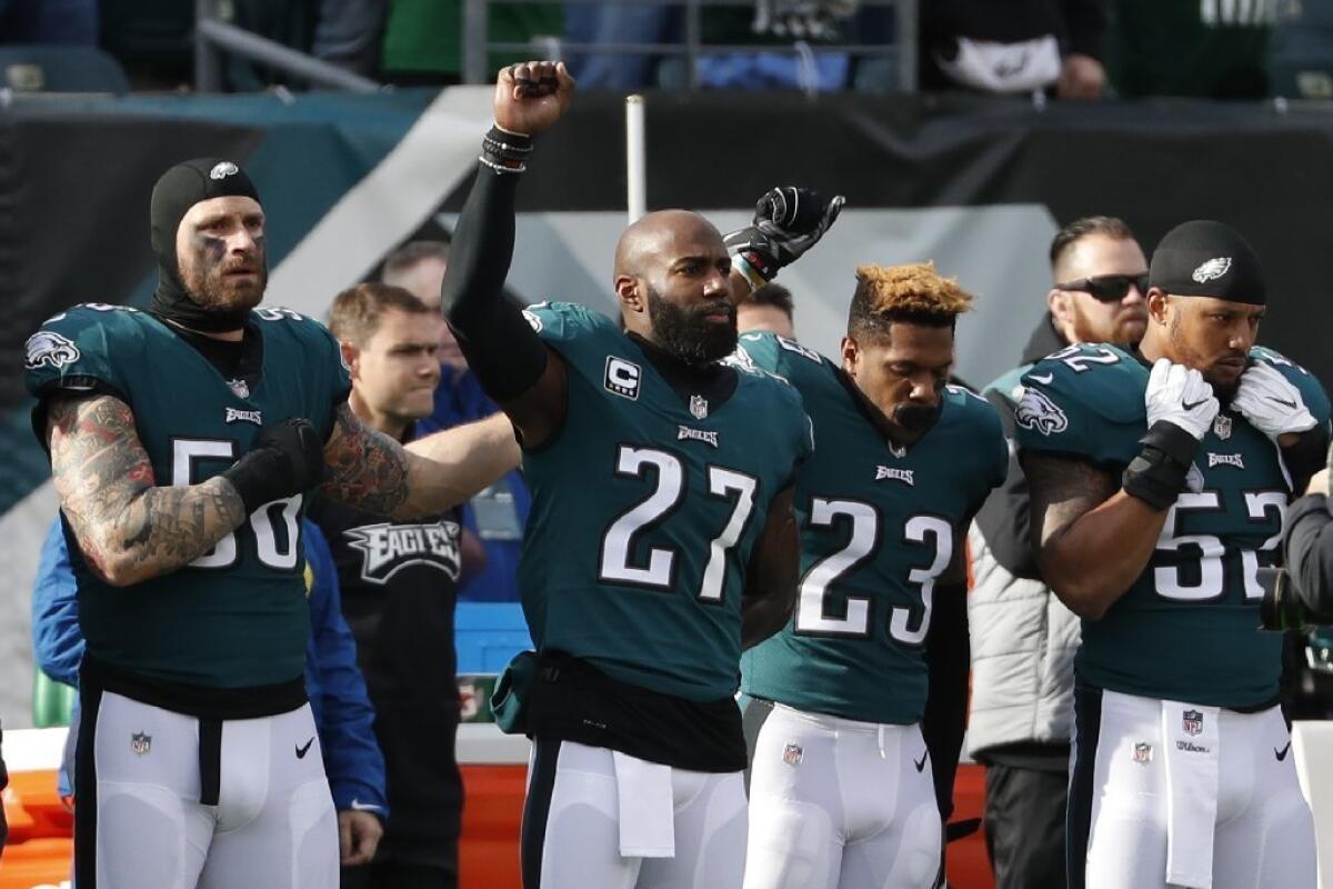 Philadelphia's Malcolm Jenkins (27) and Rodney McLeod (23) raise their arms during the national anthem before a game against Chicago.
