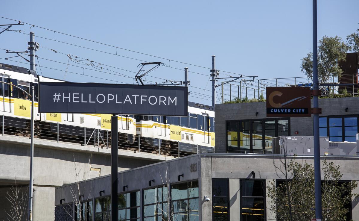 The shopping center's #helloplatform sign adjacent to the elevated Metro rail line.