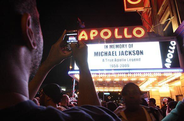 Tshaka Lafayette takes a picture of the marquee at the Apollo Theater as people gather to remember Michael Jackson in the Harlem neighborhood of New York. "I'm trying to capture a piece of American history," said Lafayette.