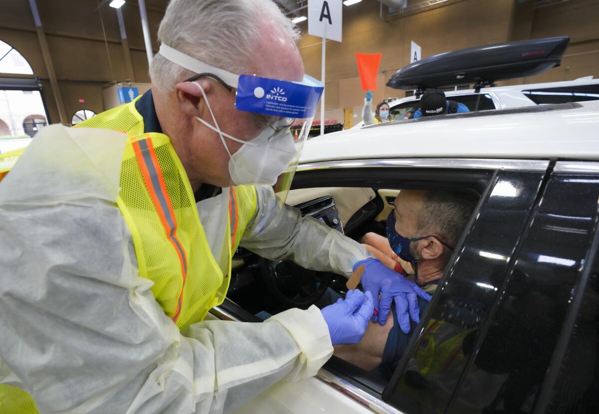 Scripps Health CEO Chris Van Gorder inoculates Christian Dollahon, 66, from Oceanside with the Pfizer vaccine on Friday 