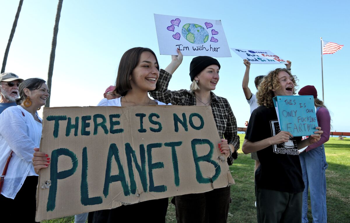 Demonstrators hold a sign saying "There is No Planet B"  during a 2019 protest at Huntington Beach High School
