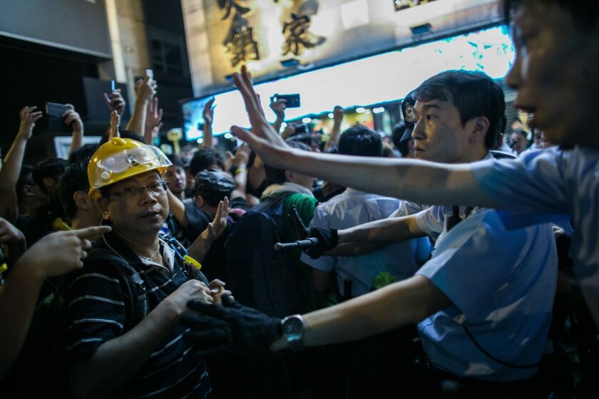 Demonstrators face off with police in the Mong Kok area of Hong Kong on Sunday as pro-democracy protests enter an eighth day.