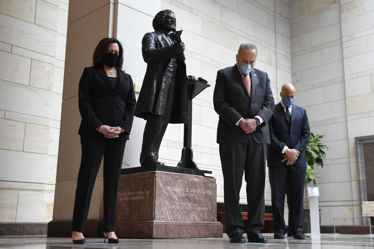 A photo of then-Sen. Kamala Harris standing near a statue of Frederick Douglass.