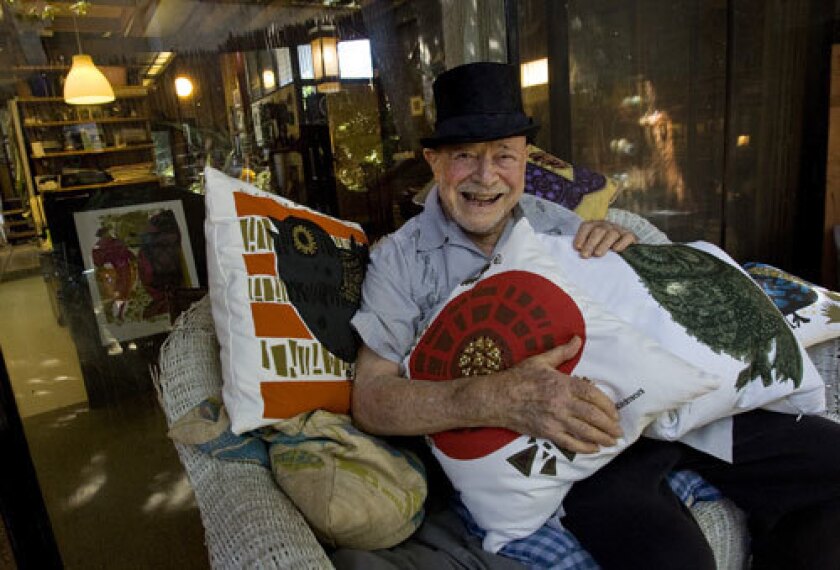 COMFY APPEAL: Outside his Highland Park studio, David Weidman holds pillows bearing his artwork. They're being sold through Urban Outfitters.