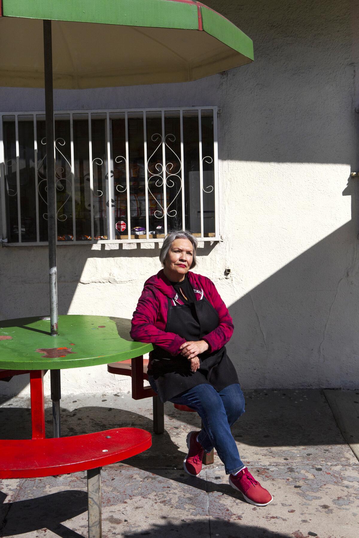 Rosario Ríos posa para una foto en su puesto de tacos en Boyle Heights.
