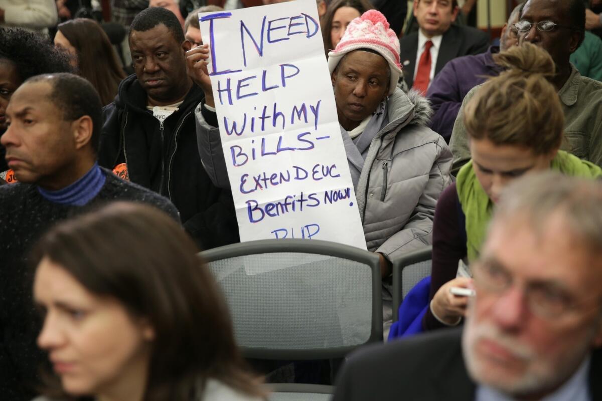 Jacqueline Chapman of Philadelphia holds a poster during a news conference in Washington at which Democratic congressional leaders and others called for an extension of unemployment insurance benefits for long-time jobless workers.