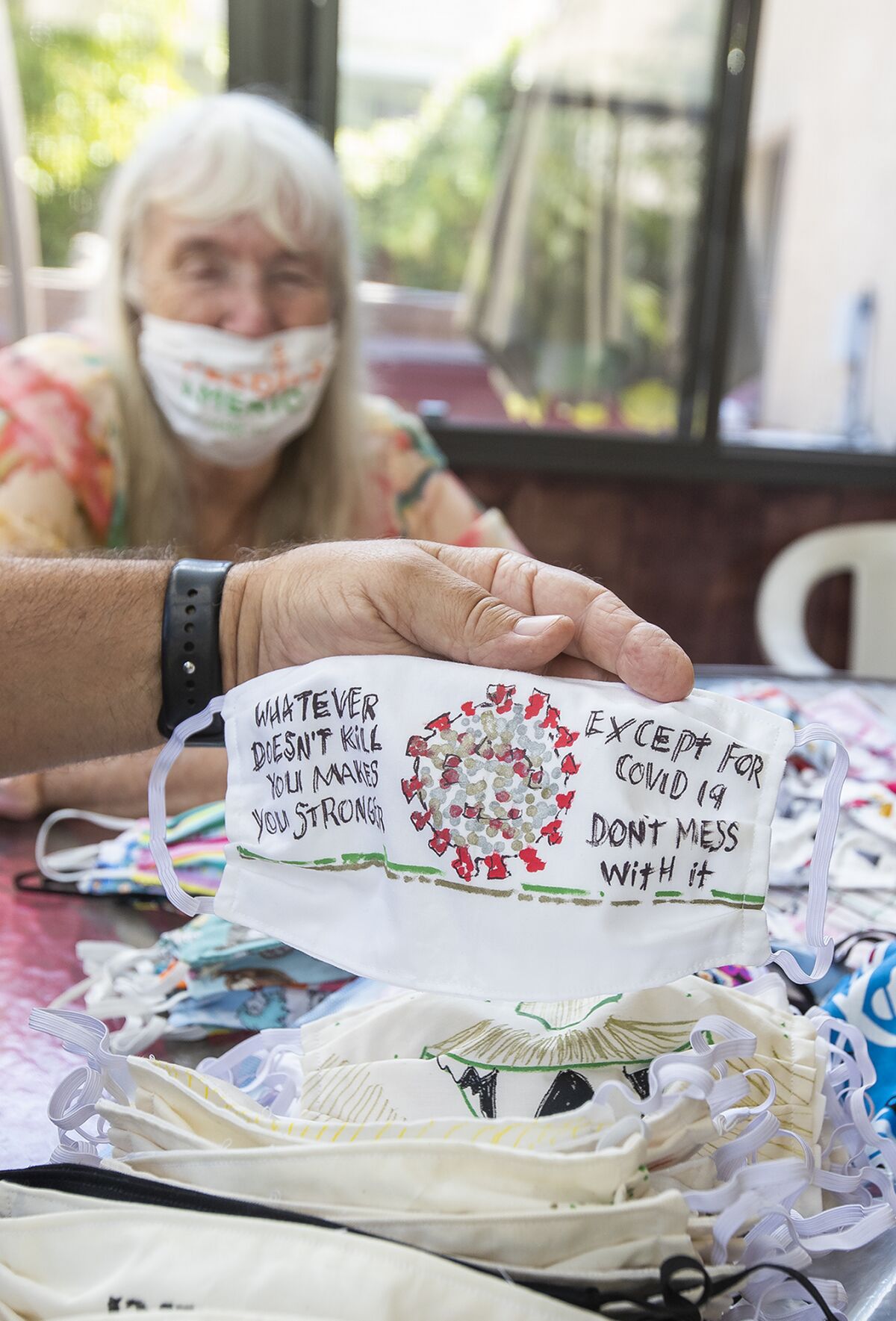 Ted Engard and his wife Peggy display a special hand-painted mask at his home on Tuesday.