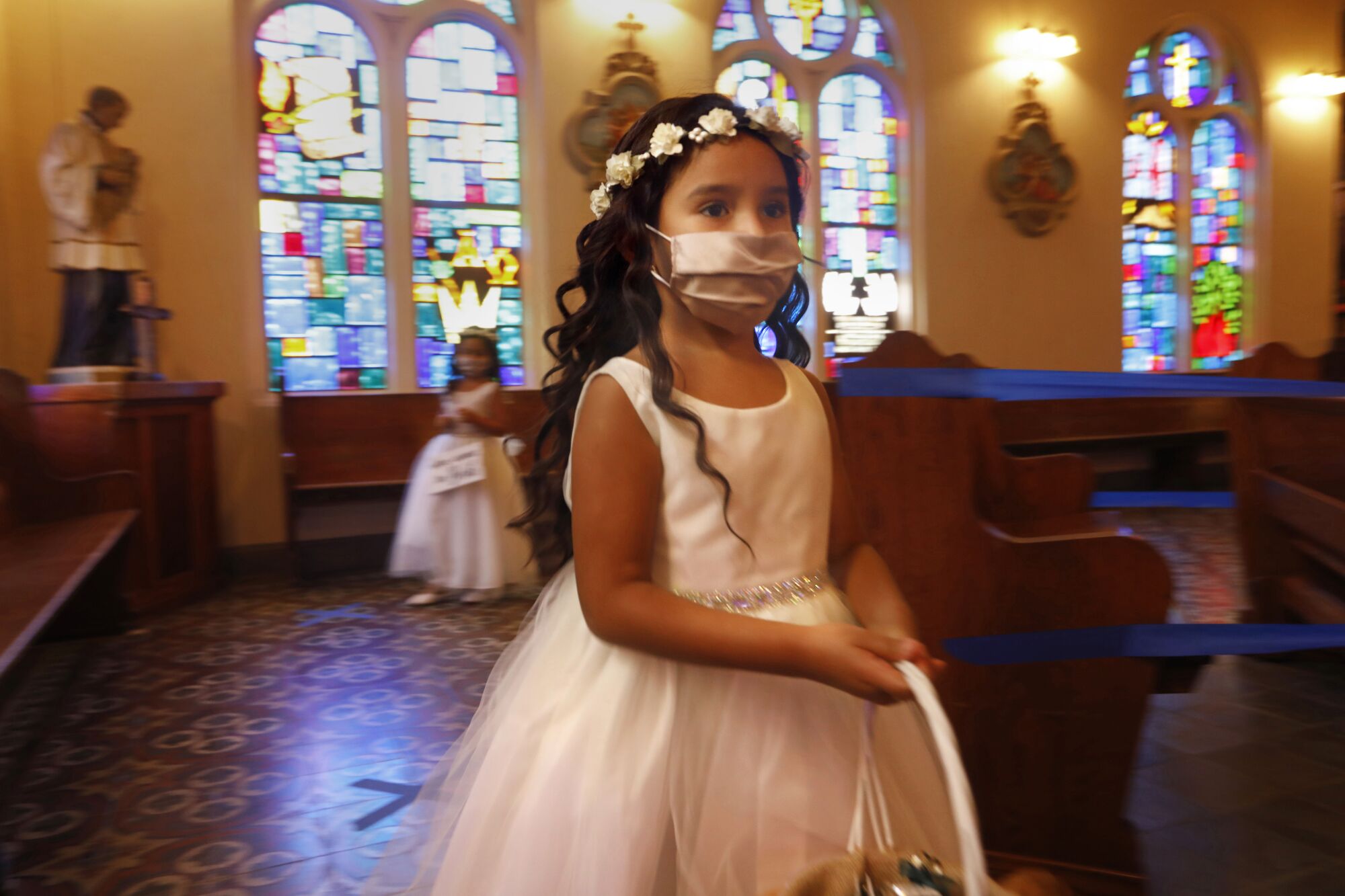 Flower girl Drea Cedillo, 5, wears a mask during a family wedding Saturday in Mission, Texas.