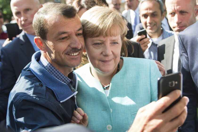 FILE - In this Sept. 9, 2015 file photo German chancellor Angela Merkel poses for a selfie with a refugee in a facility for arriving refugees in Berlin. The U.N. refugee agency says it's giving its highest award to former German Chancellor Angela Merkel for her efforts to bring in more than 1 million refugees — mostly from Syria — into Germany, despite some pockets of criticism at both home and abroad. (Bernd von Jutrczenka/dpa via AP, File)