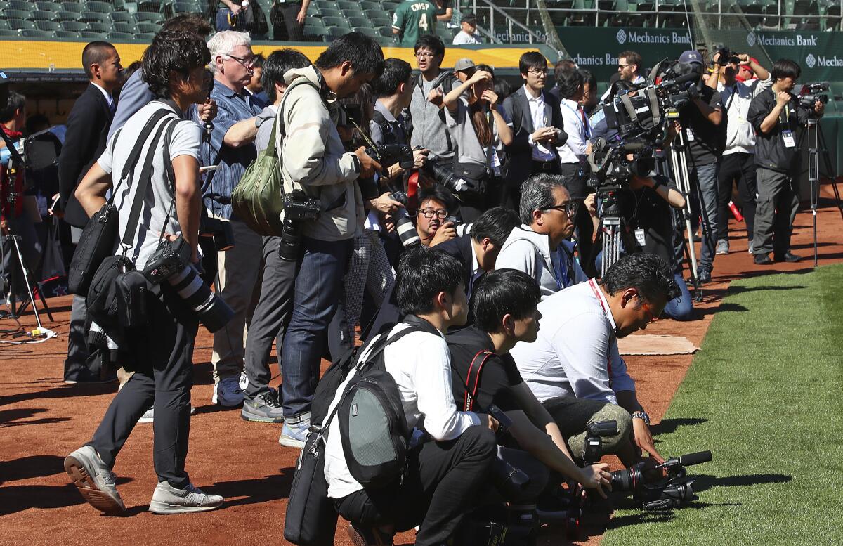 Media gather in front of the Angels' dugout as they await Shohei Ohtani to return from batting practice.