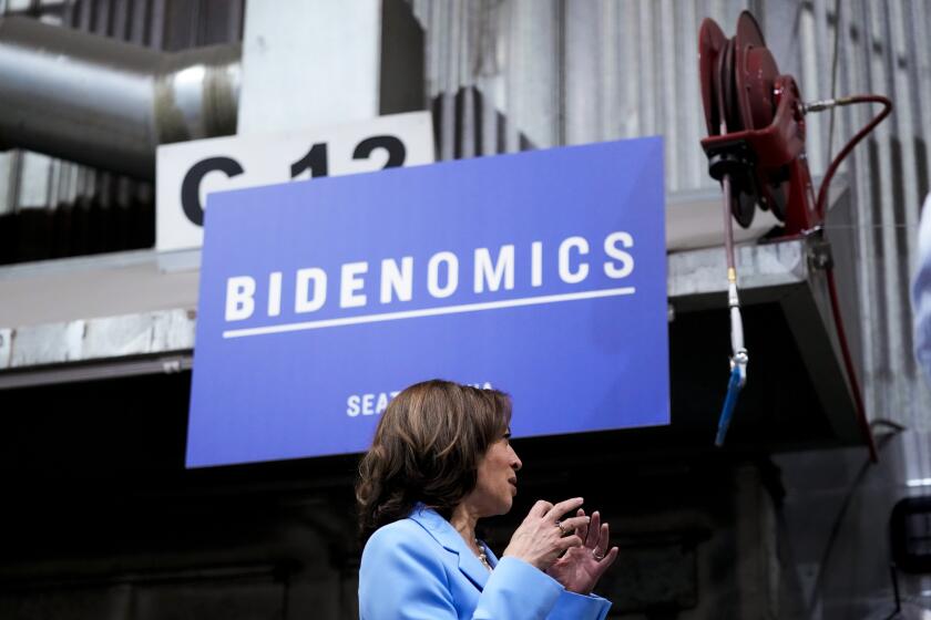Vice President Kamala Harris stands in front of a "Bidenomics" sign as she tours McKinstry's factory after giving a speech ahead of the one-year anniversary of the Biden administration's Inflation Reduction Act, Tuesday, Aug. 15, 2023, in Seattle. (AP Photo/Lindsey Wasson)