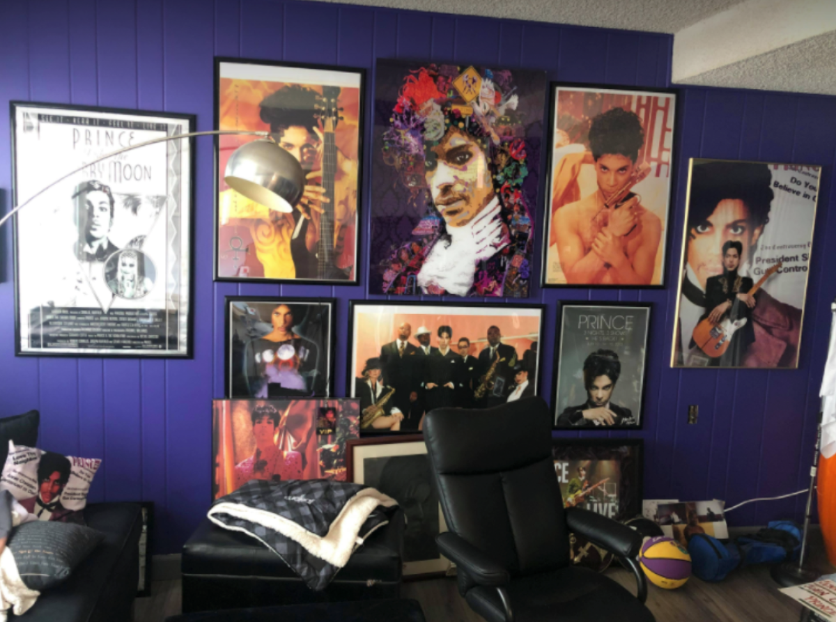Multiple framed photos of the musician Prince are arranged on a purple wall. 