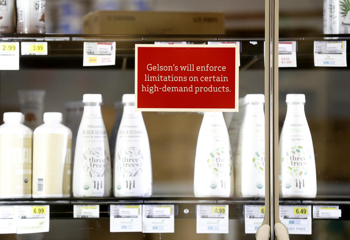 Signs notify customers of limitations on high-demand products at Gelson's Market in Manhattan Beach.