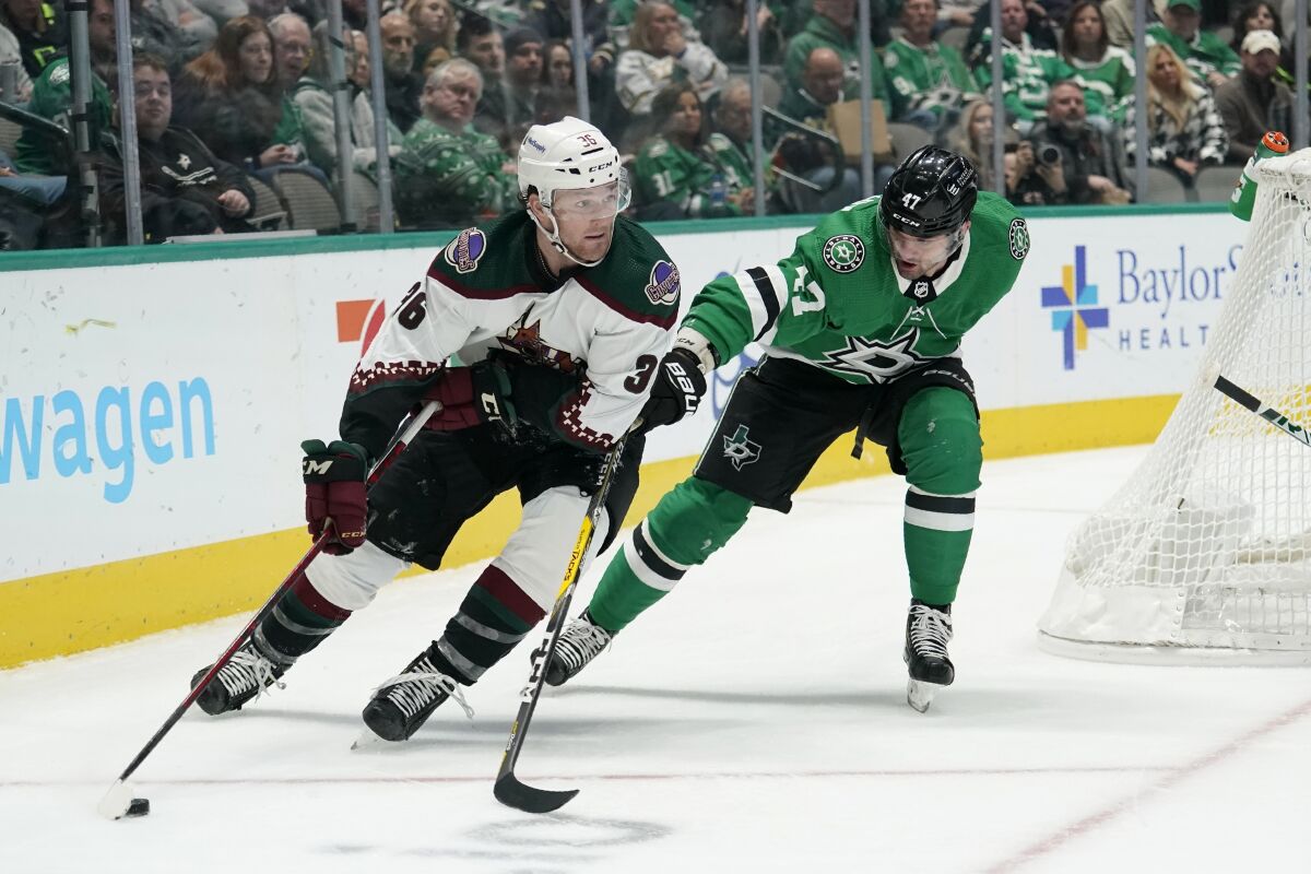 Arizona Coyotes right wing Christian Fischer (36) looks to make a pass as Dallas Stars right wing Alexander Radulov (47) defends in the second period of an NHL hockey game in Dallas, Monday, Dec. 6, 2021. (AP Photo/Tony Gutierrez)
