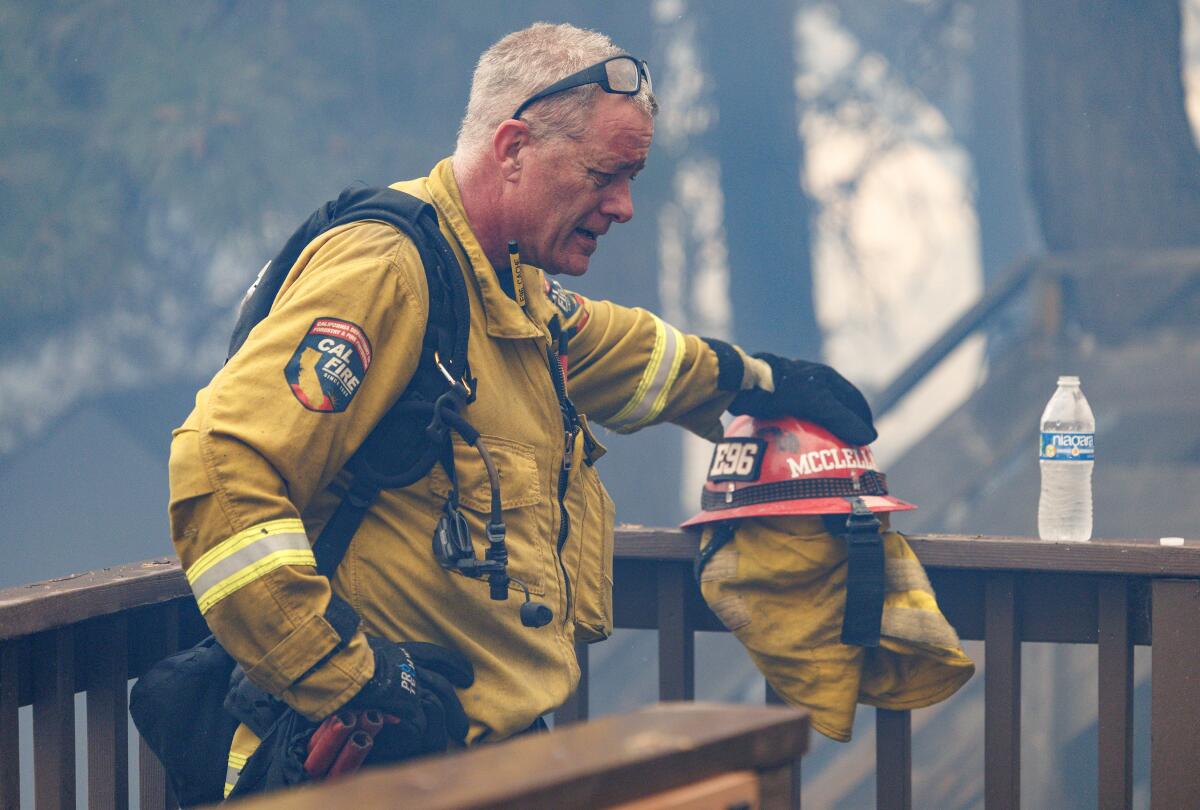 A firefighter takes a break on a deck amid smoky air 