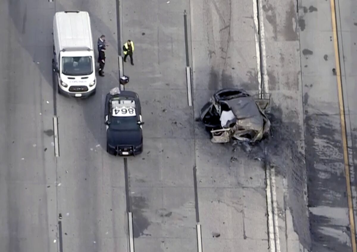 Overhead view of a police car and van parked next to a mangled vehicle involved in a crash