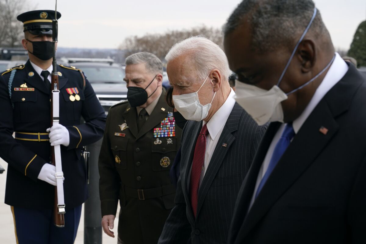President Joe Biden walks with Joint Chiefs Chairman Gen. Mark Milley, and Defense Secretary Lloyd Austin