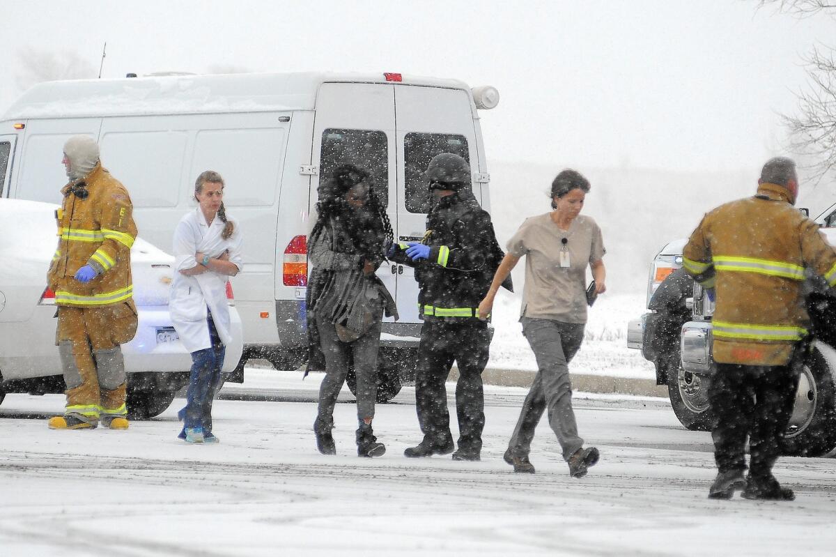 People are escorted away from a deadly shooting Nov. 27 at a Planned Parenthood clinic in Colorado Springs, Colo.