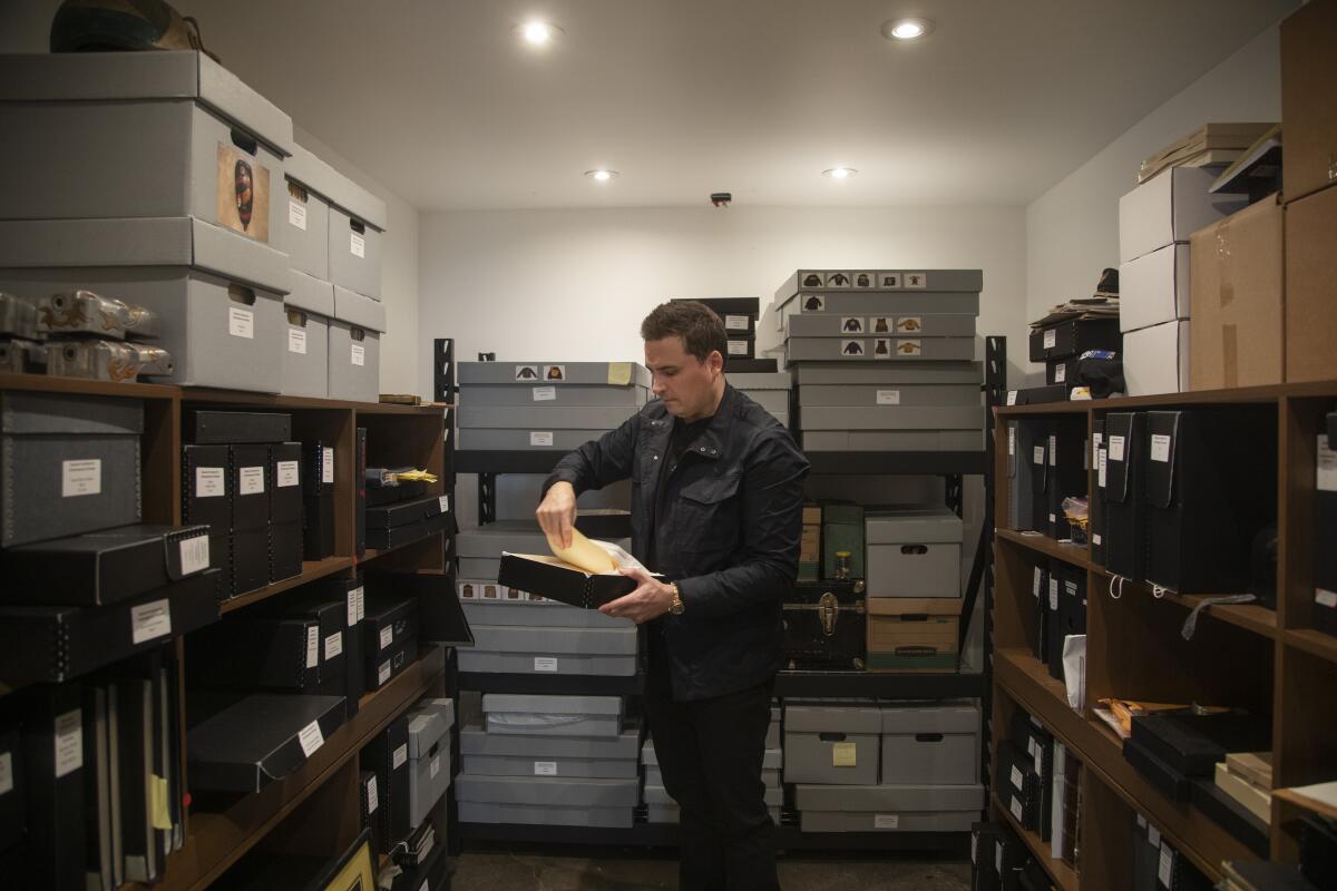 A man with a file among shelving. 