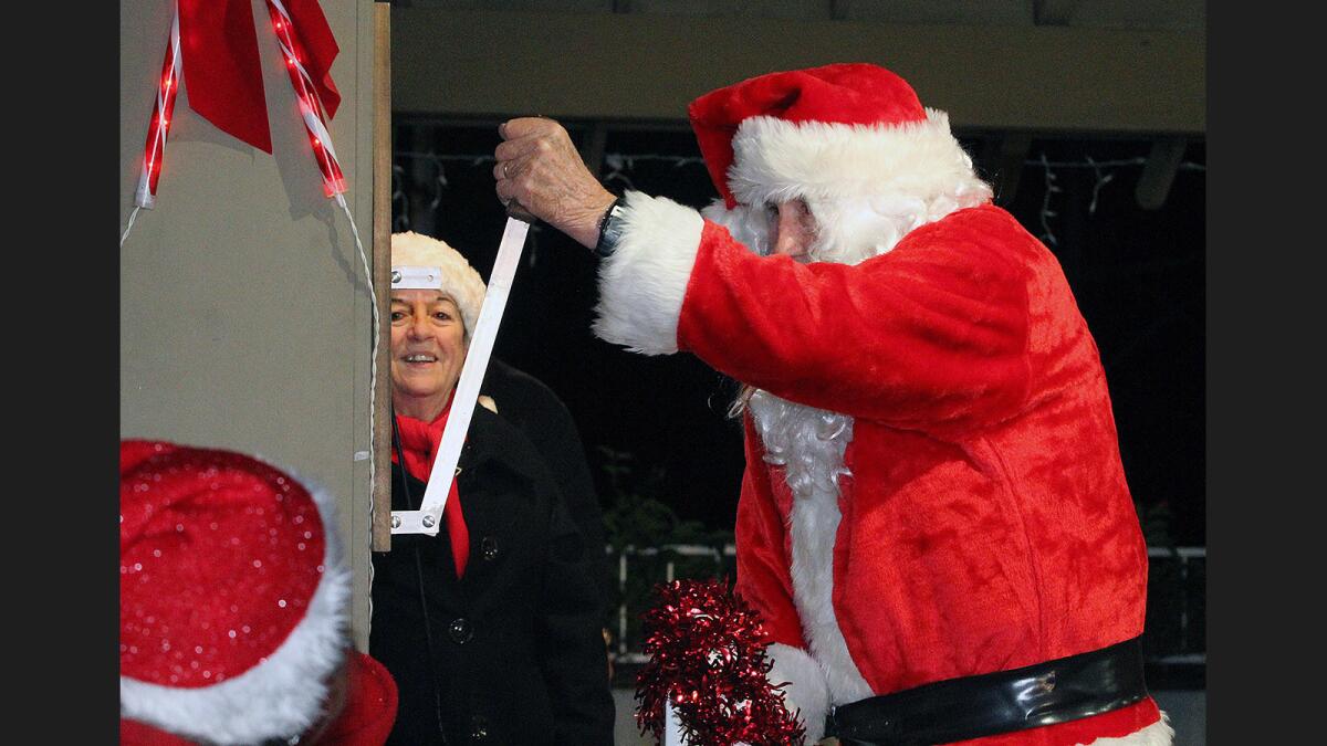 A lever, pushed by Santa, lights up the pavilion at Memorial Park at the La Cañada Flintridge Chamber of Commerce's 22nd annual Festival in Lights on Friday, Dec. 2, 2016.