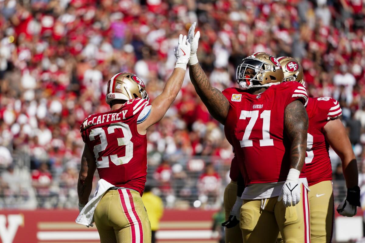 San Francisco 49ers running back Christian McCaffrey celebrates with offensive tackle Trent Williams.