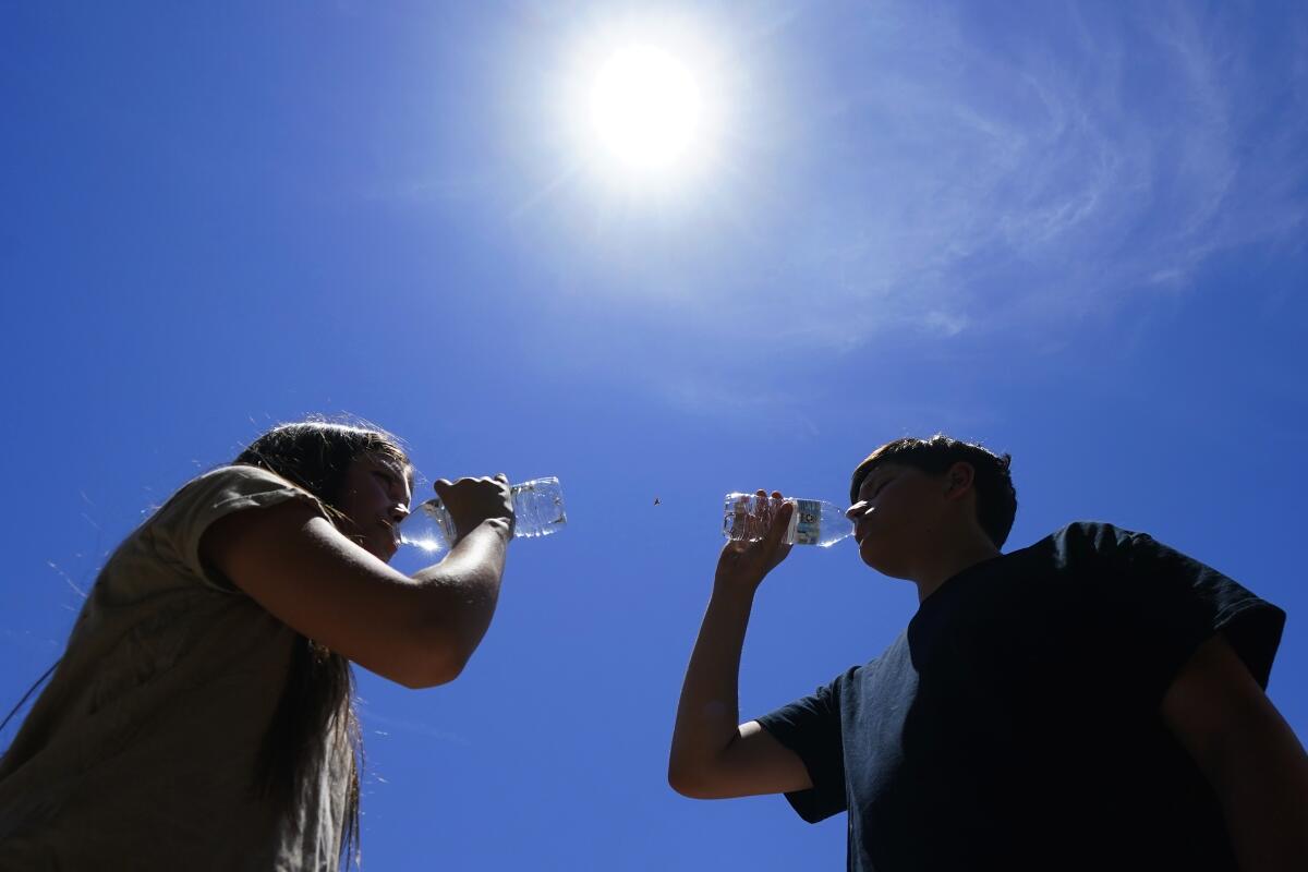 Youths drinking water under high sun