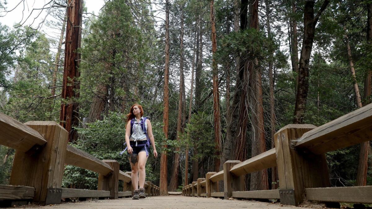 Victoria Matlock, 23, of Orlando, Fla., walks along Upper Yosemite Fall trail as Yosemite Valley reopens in Yosemite, Calif., on Aug. 14, 2018. The Yosemite Valley reopened as firefighters strengthen containment of the Ferguson fire.