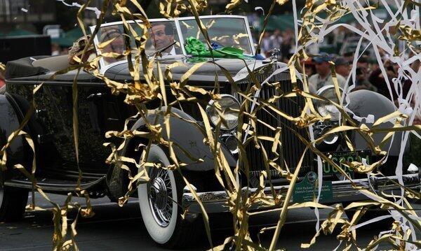 Joseph C. Cassini drives his 1934 Packard 1108 Twelve Dietrich Convertible Victoria onto the winners platform after being awarded the Best of Show award at the Pebble Beach Concours d'Elegance.