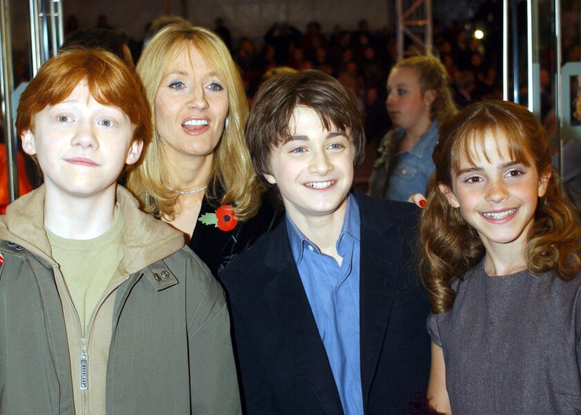 J.K. Rowling in 2001 with the then-young stars of the Harry Potter film franchise, from left: Rupert Grint (Ron), Daniel Radcliffe (Harry) and Emma Watson (Hermione). In a coming interview, Rowling is said to have reconsidered the Hermione-Ron romance.