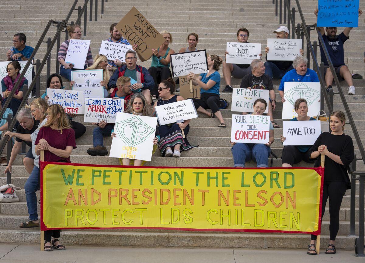 Protesters gather on the steps of the Utah State Capitol, at a rally to gain support for removing the clergy exemption from mandatory reporting in cases of abuse and neglect, on Friday, Aug. 19, 2022 in Salt Lake City. Demonstrators gathered outside the Utah Capitol on Friday to demand lawmakers remove an exemption from state law that frees religious leaders from being required to report sexual abuse when perpetrators mention it in confessions. (Rick Egan/The Salt Lake Tribune via AP)