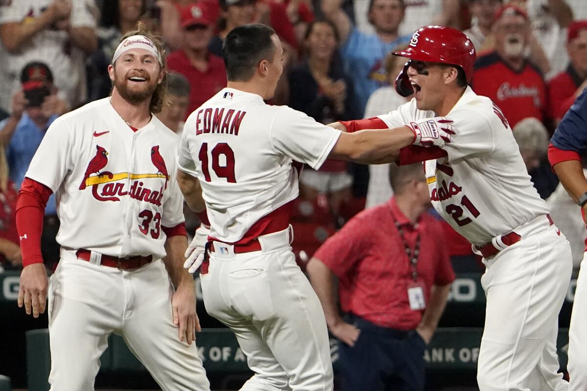 St. Louis Cardinals' Tommy Edman (19) is congratulated by teammates Brendan Donovan (33) and Lars Nootbaar (21) after hitting a two-run double to defeat the Washington Nationals 6-5 in a baseball game Wednesday, Sept. 7, 2022, in St. Louis. (AP Photo/Jeff Roberson)