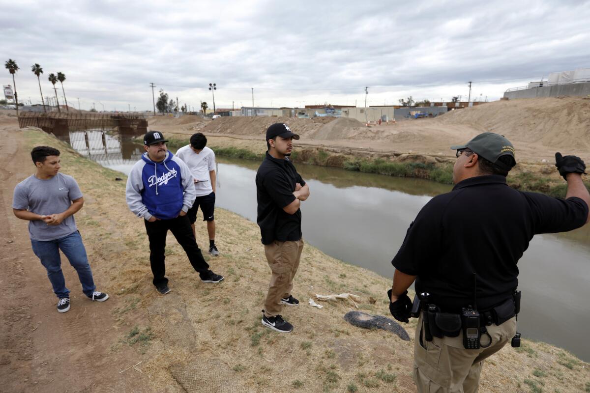 Joel Merino, right, of the Border Patrol instructs trainees on the hazards of the New River.