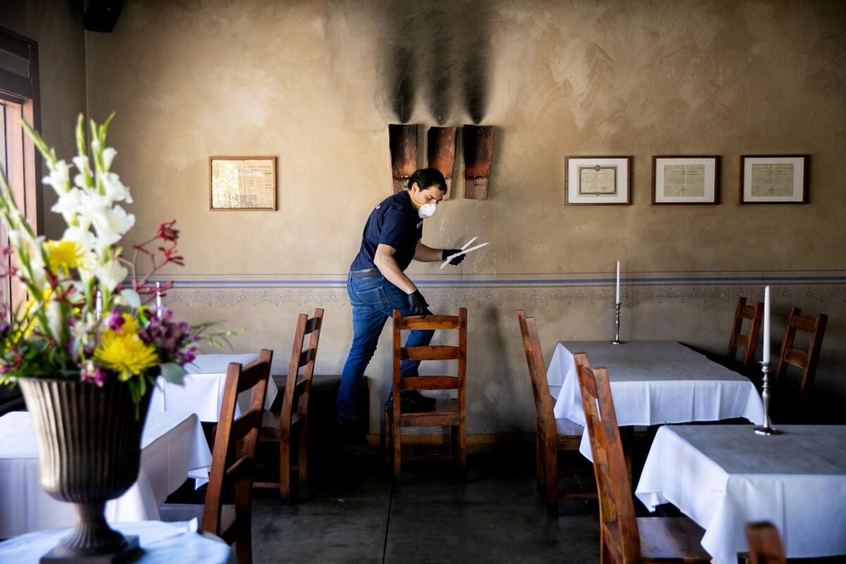 Server Leoonel Serrentino lights candles at Bleu Boheme restaurant in San Diego as it prepared to reopen in May