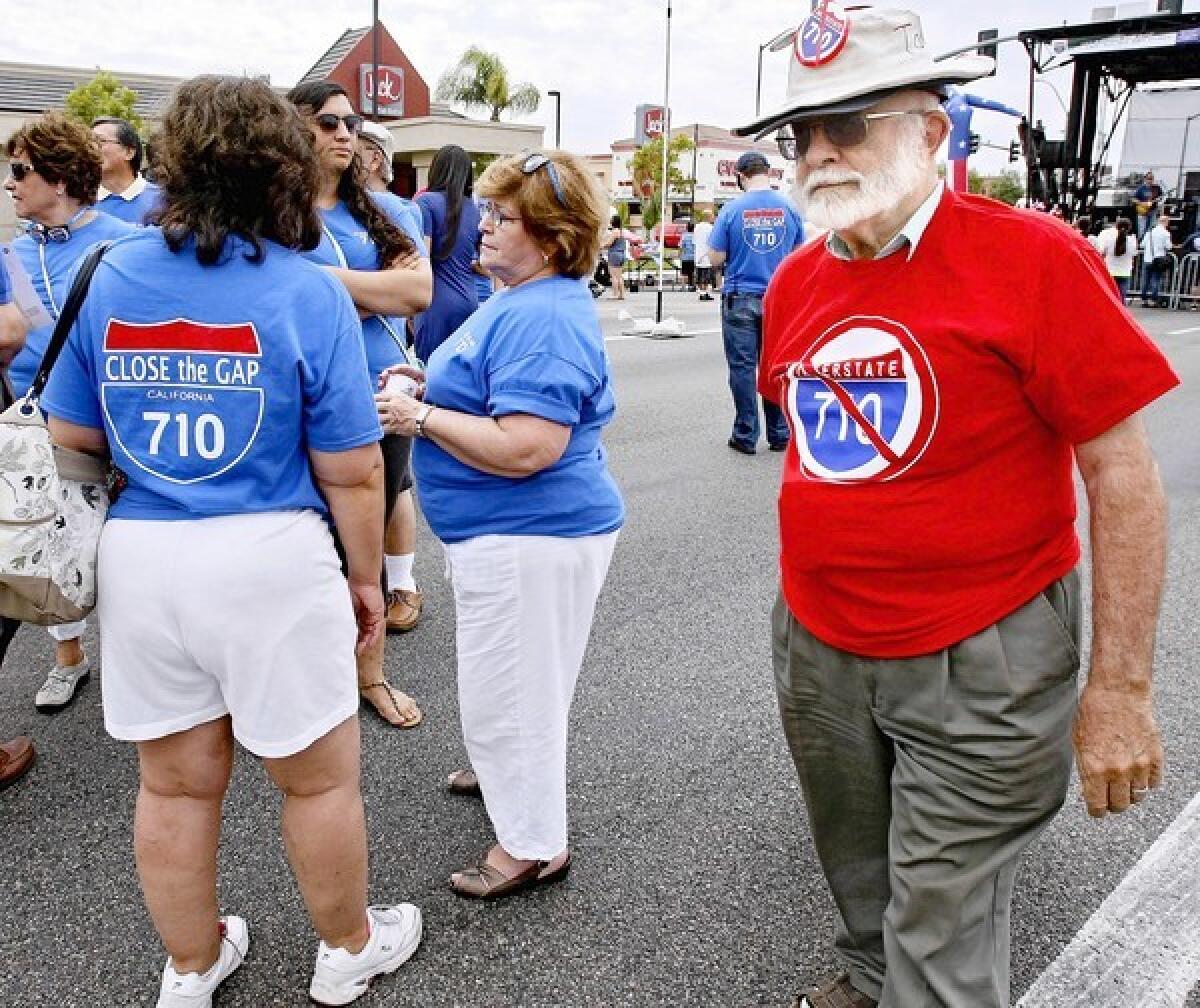 Wearing his "No to 710 extension" pin and shirt, Tom Williams of El Sereno passes supporters of the 710 Freeway extension during the City of Alhambra "710 Day" celebration on Wednesday, July 10, 2013. Fremont Avenue was closed for two blocks north of Valley Boulevard to make room for a stage, booths and lunch trucks. Some opponents of the extension also attended the event.