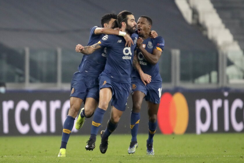Porto's Sergio Oliveira, center, celebrates after scoring his side's second goal during the Champions League, round of 16, second leg, soccer match between Juventus and Porto in Turin, Italy, Tuesday, March 9, 2021. (AP Photo/Luca Bruno)