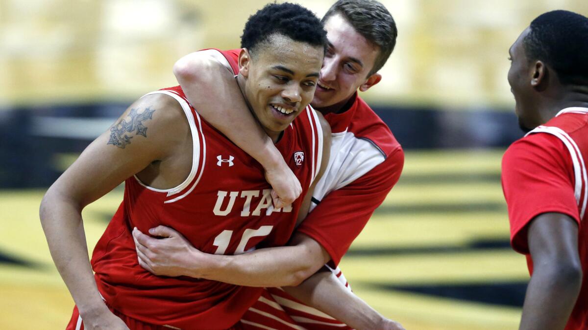 Utah guard Lorenzo Bonam is hugged by a teammate after scoring the winning basket against Colorado on Friday night.