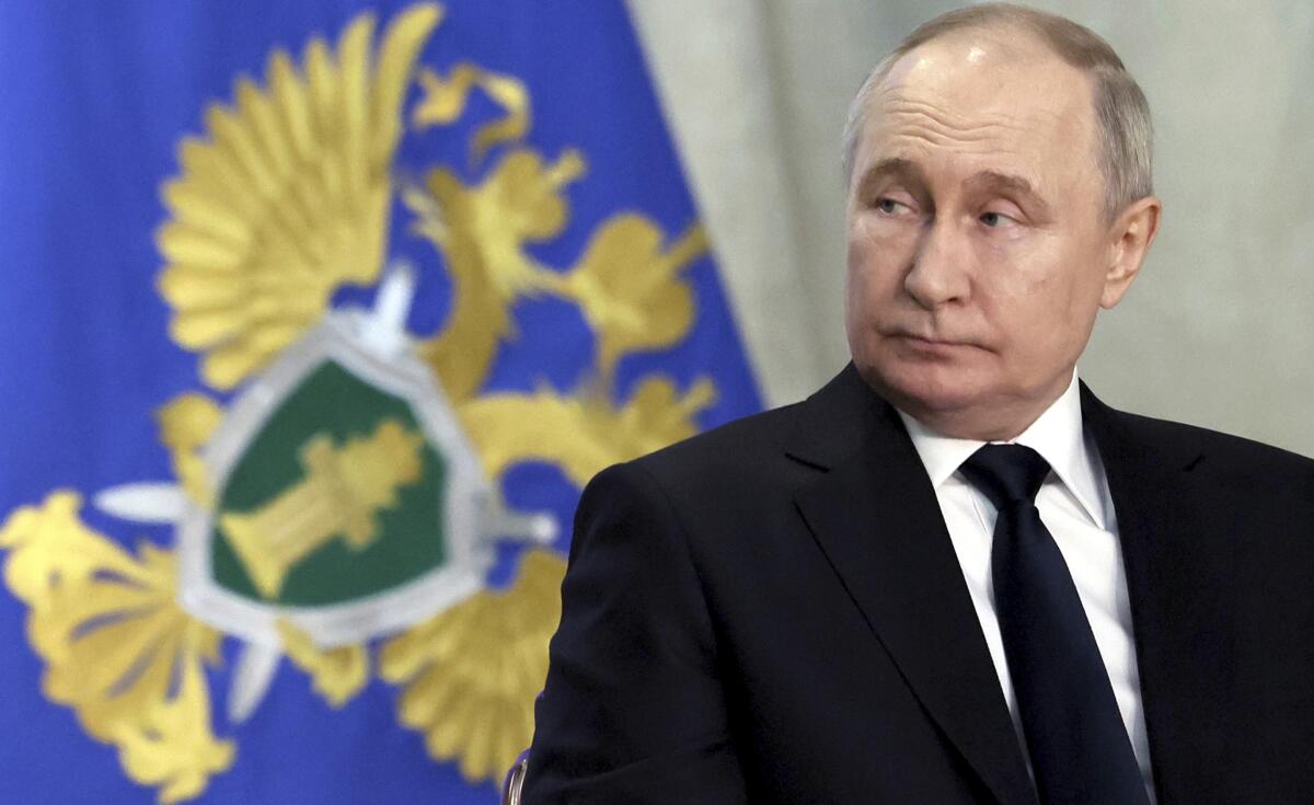 Russian President Vladimir Putin looks to the side