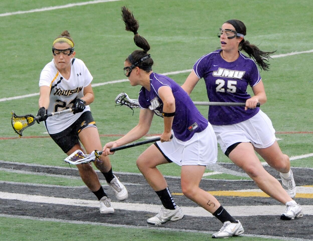 Towson's Sarah Hogan, left, battles James Madison's Caitlin McHugh, center, and Monica Zabel for a loose ball in the first half.