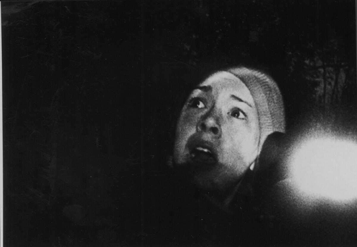 A young woman in a grainy photo looks scared in "The Blair Witch Project."