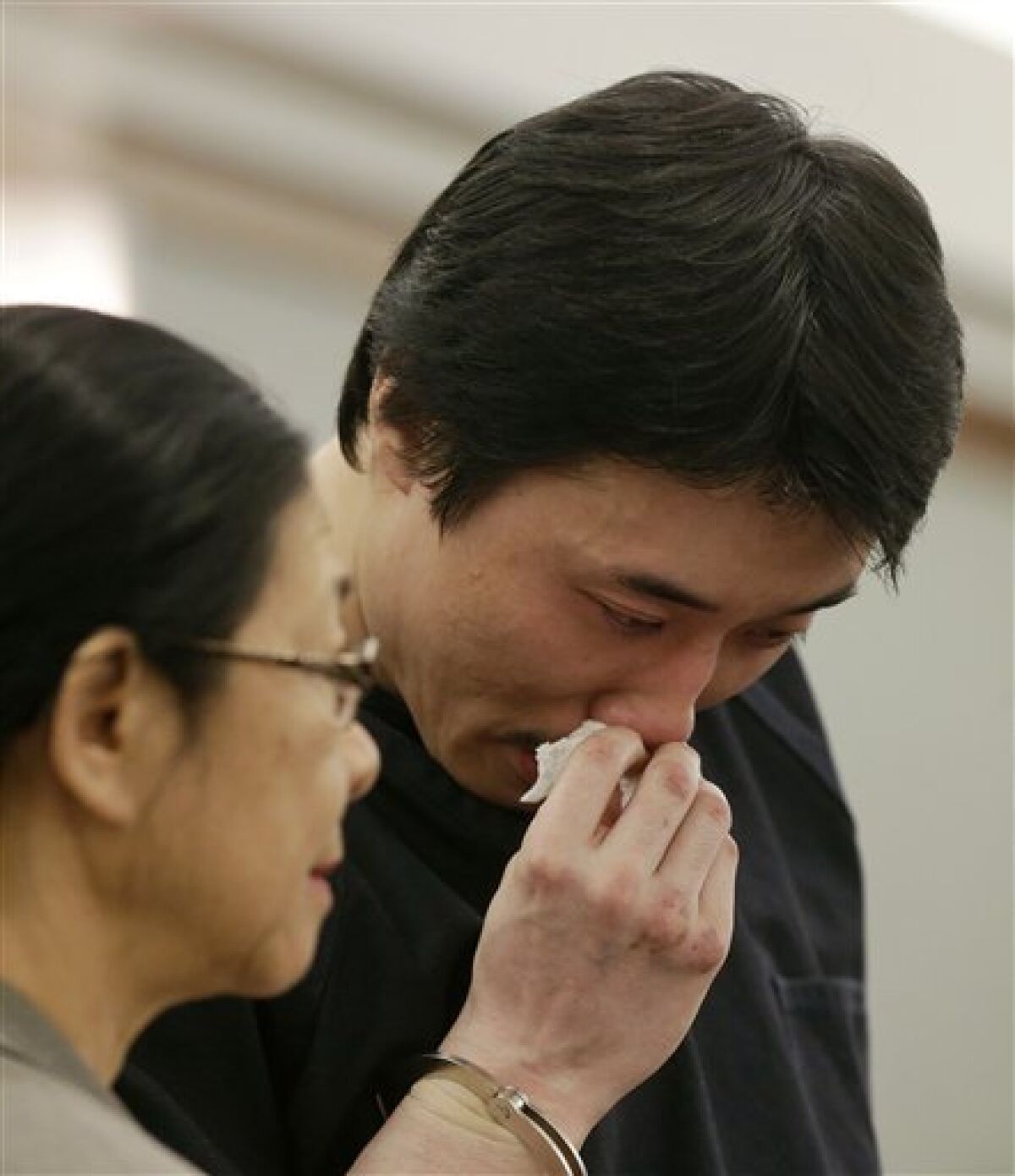 Xiao Ye Bai reacts as he reads a statement to the court during his sentencing, Tuesday, March 5, 2013, in Las Vegas. The 26-year-old Chinese immigrant, convicted of being an enforcer for a Taiwan-based criminal gang, will spend the rest of his life in a Nevada prison for killing one person and wounding two others in a bloody knife attack in a Las Vegas karaoke bar in July 2009. (AP Photo/Julie Jacobson)