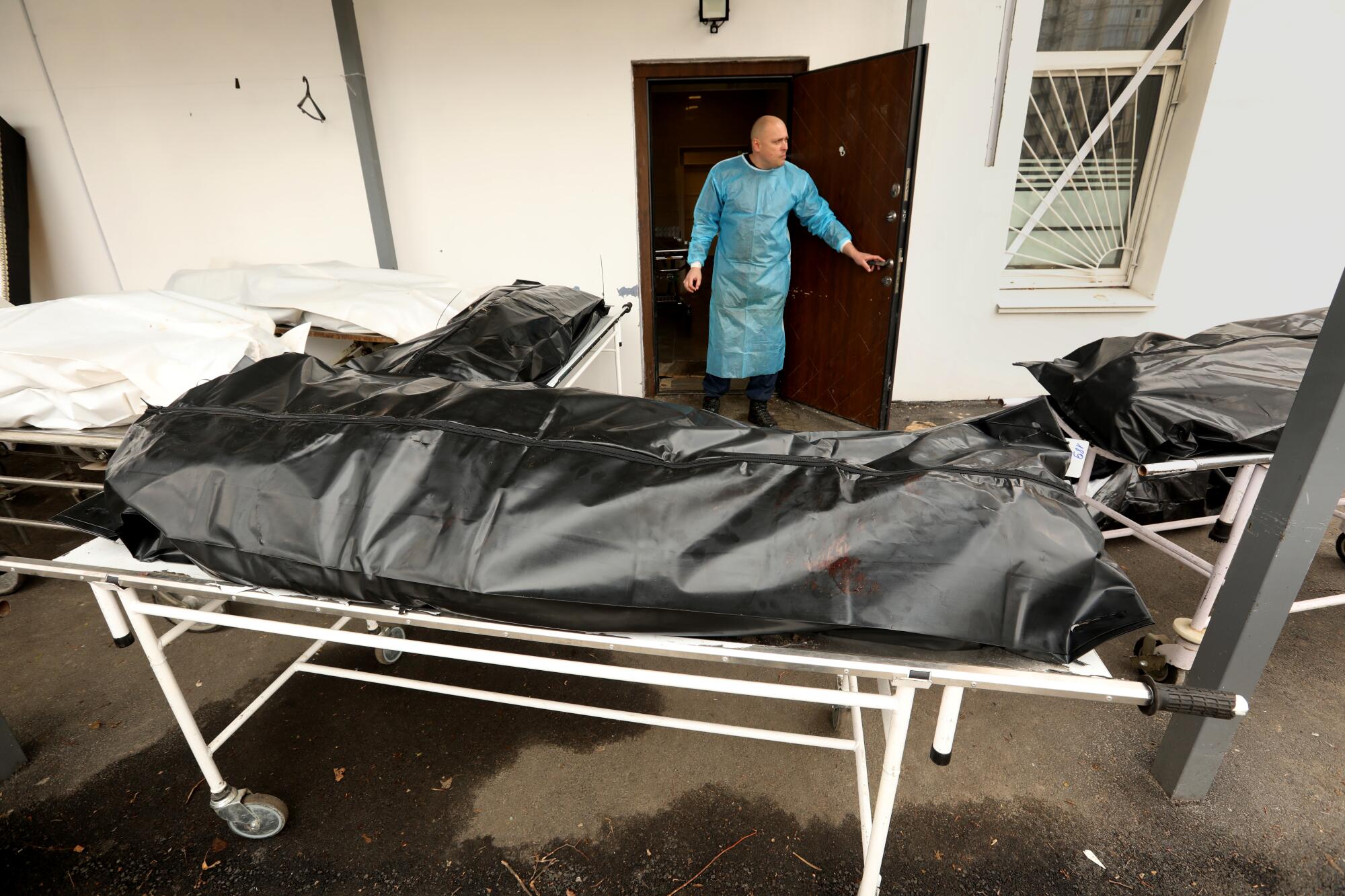 Body bags on gurneys outside the morgue in Bucha, Ukraine.