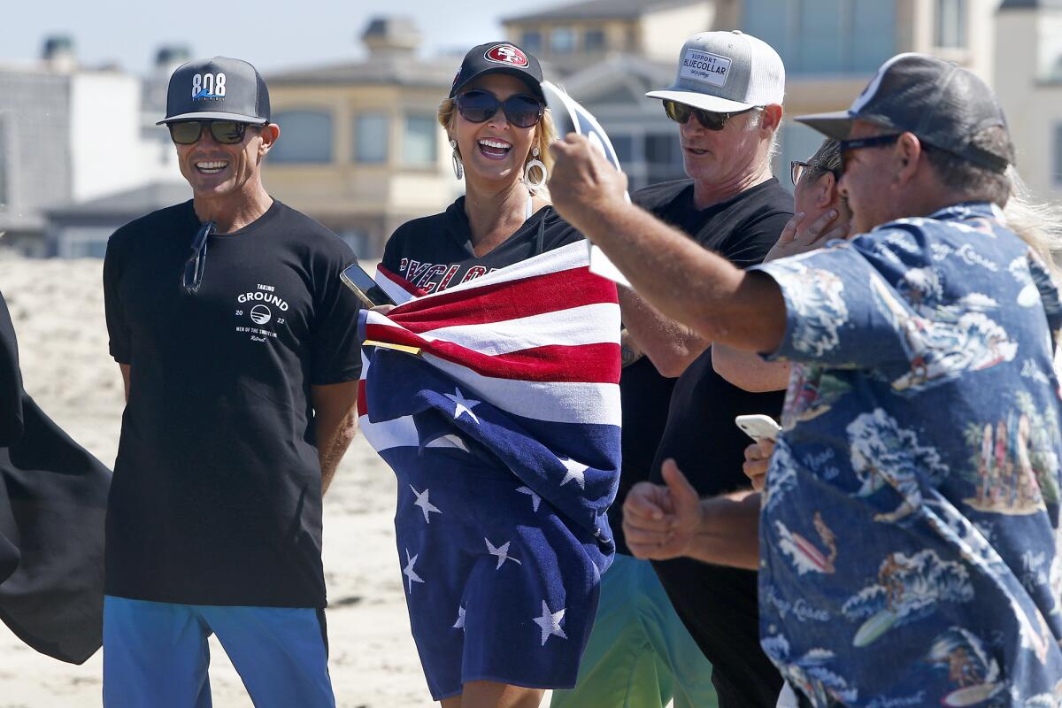 Carrie Purdy laughs after World Surfing Champion Peter "PT" Townend holds up a score of 1.