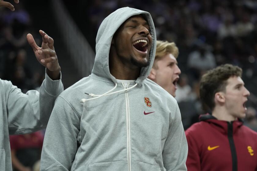 Southern California guard Bronny James cheers for his team from the bench.