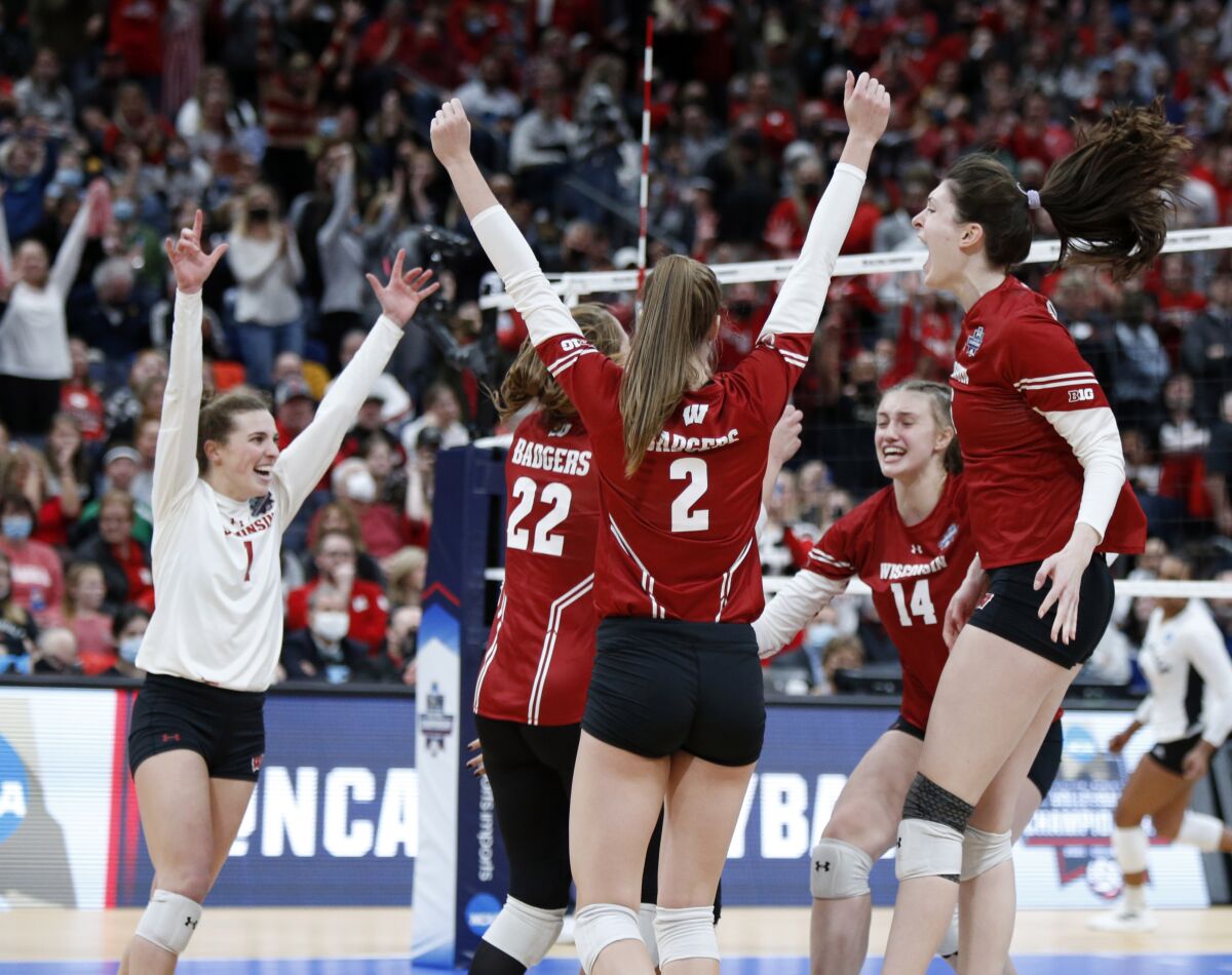 Wisconsin's Lauren Barnes (1), Julie Orzol (22), Sydney Hilley (2), Anna Smrek (14) and Dana Rettke, right, celebrate a win over Louisville in a semifinal of the NCAA women's college volleyball tournament Thursday, Dec. 16, 2021, in Columbus, Ohio. (AP Photo/Paul Vernon)